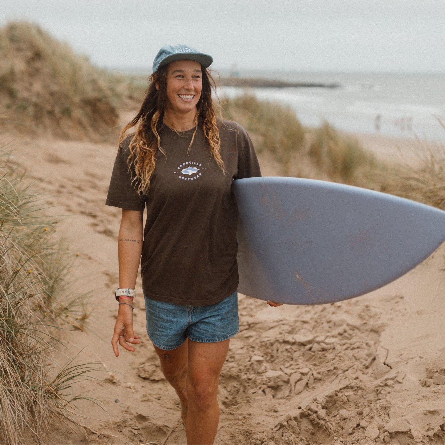 Woman holding a surfboard on a beach
