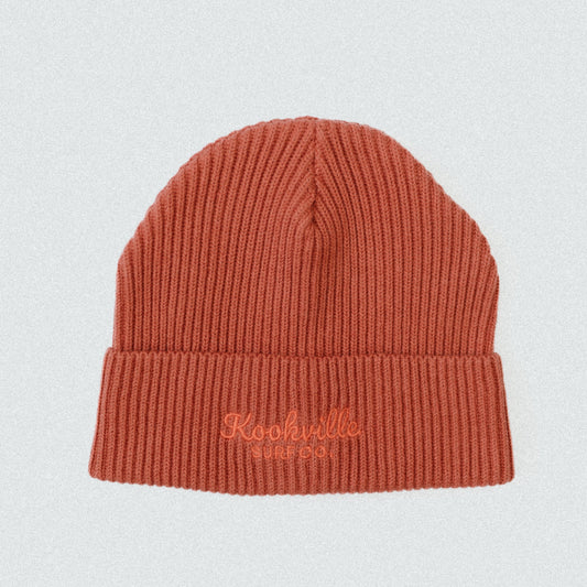 Orange knit beanie with 'Kookville' embroidery on a light gray background