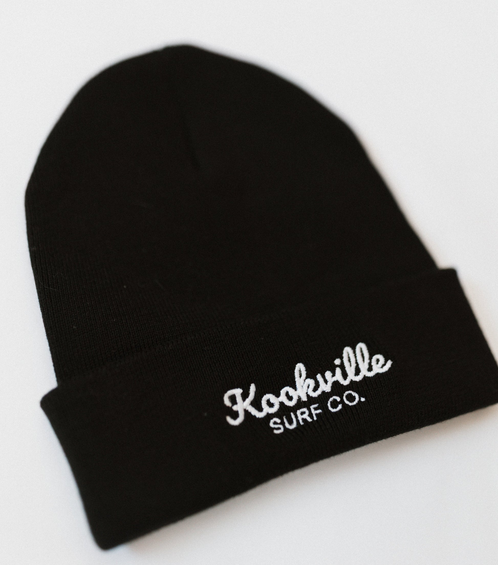 Black beanie with 'Kookville Surf Co.' embroidery on a white background