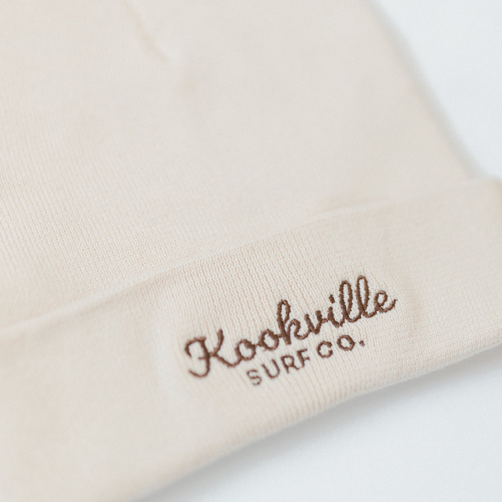 Natural Beanie with 'Kookville Surf Co.' embroidery in brown on a white background