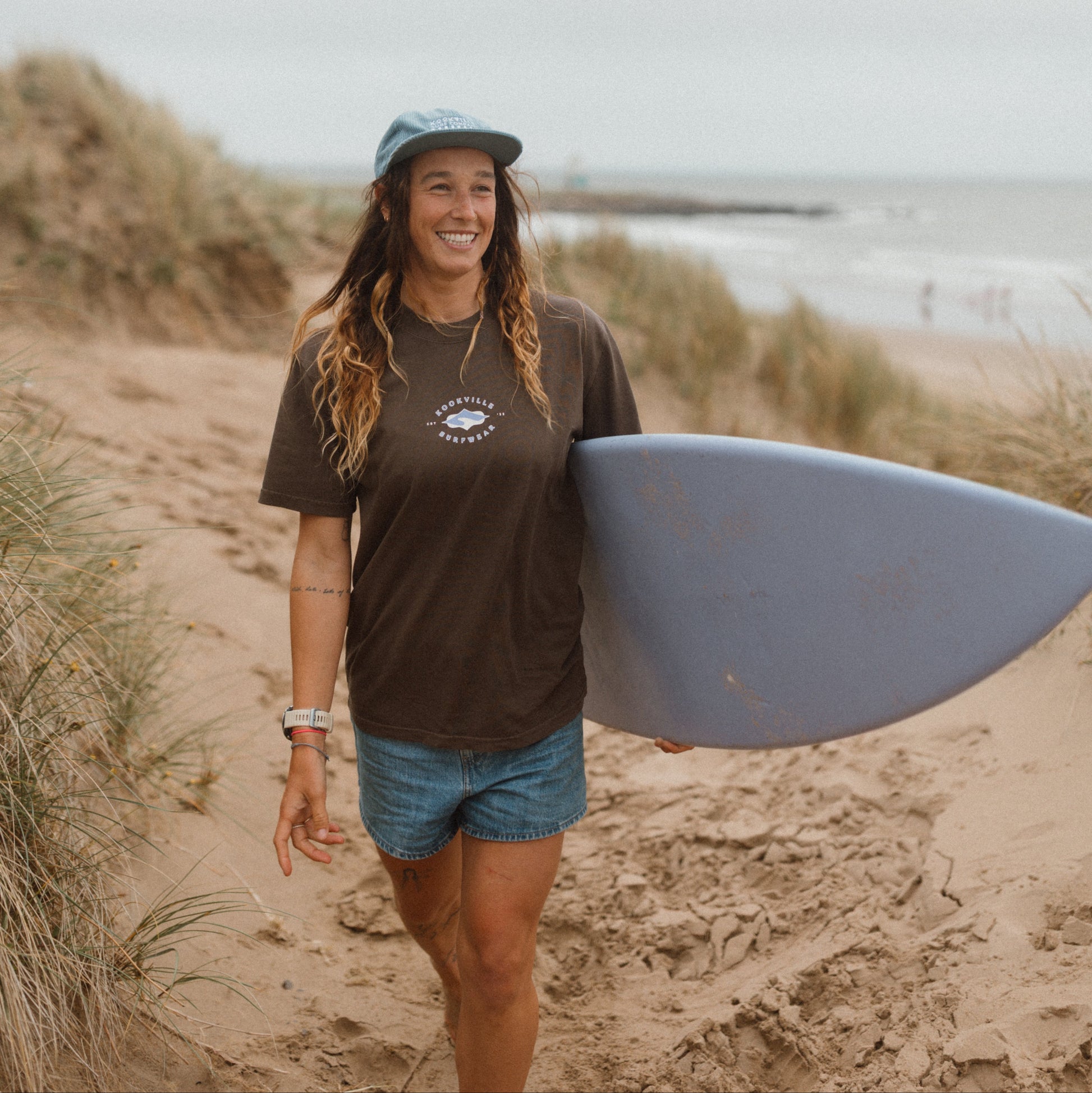 Woman holding a surfboard on a beach